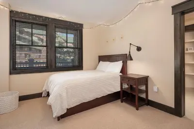 a bedroom with a bed and a table and windows at Parry Peak Loft Premium-Rated 105 in Winter Park