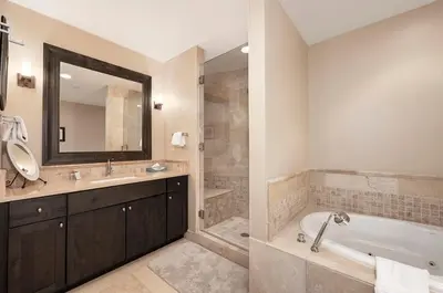 a bathroom with a tub and a sink and a mirror at Parry Peak Loft Premium-Rated 105 in Winter Park