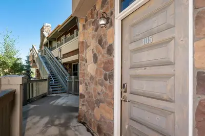 a door to a house with a stone wall at Parry Peak Loft Premium-Rated 105 in Winter Park