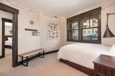 a bedroom with a bed and a table and a window at Parry Peak Loft Premium-Rated 105 in Winter Park