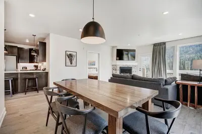 a kitchen and living room with a wooden table and chairs at Brand New Clear Water Lofts - 2br Premier Condo - Kids Ski Free, No CF condo in Keystone