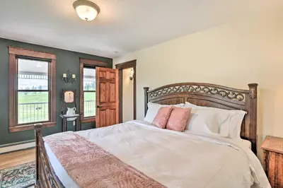 a bedroom with a bed with white sheets and pink pillows at Mtn View and Group Ready Conifer Home on 100 Acres! in Conifer