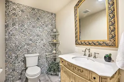 a bathroom with a toilet and a sink and a mirror at Mtn View and Group Ready Conifer Home on 100 Acres! in Conifer