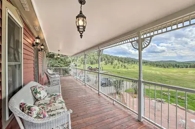 a porch with a couch and chairs on a balcony at Mtn View and Group Ready Conifer Home on 100 Acres! in Conifer