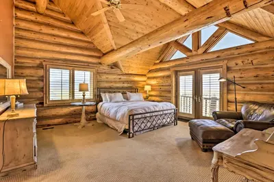 a log cabin bedroom with a bed and a couch at Skiing and Hiking Access Spacious Granby Cabin! in Granby