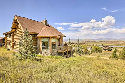 a log cabin with a deck in a field at Skiing and Hiking Access Spacious Granby Cabin! in Granby