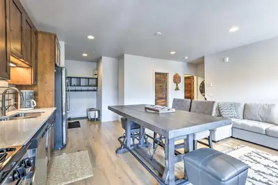 a kitchen and living room with a table and a couch at 3 Mi to Dillon Reservoir Condo with Balcony! in Silverthorne
