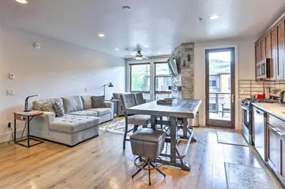 a kitchen and living room with a table and a couch at 3 Mi to Dillon Reservoir Condo with Balcony! in Silverthorne