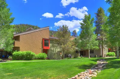a house with a yard with green grass at Luxury 2 Bedroom Condo with Pool Hot Tub and Sauna in Keystone