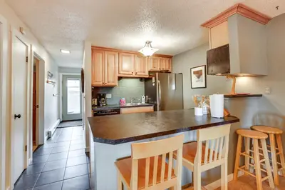a kitchen with wooden cabinets and a counter top at Silverthorne Condo with Lake Views 10 Mi to Skiing! in Silverthorne