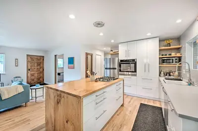 a kitchen with white cabinets and a wooden counter top at Less Than 3 Mi to Pearl St Home with Large Yard in Boulder in Boulder