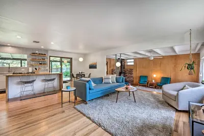 a living room with a blue couch and a kitchen at Less Than 3 Mi to Pearl St Home with Large Yard in Boulder in Boulder