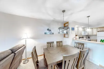 a kitchen and dining room with a wooden table and chairs at Cozy Fraser Cabin in Fraser
