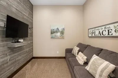 a living room with a couch and a flat screen tv at Elk Creek Condos B103 by Stay Winter Park in Fraser
