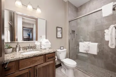 a bathroom with a toilet and a sink and a shower at Elk Creek Condos B103 by Stay Winter Park in Fraser