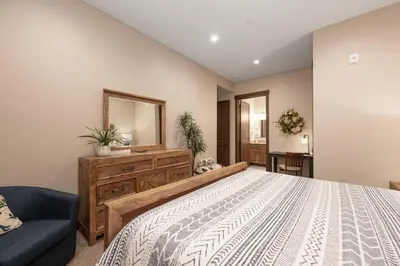 a bedroom with a large bed and a blue couch at Elk Creek Condos B103 by Stay Winter Park in Fraser