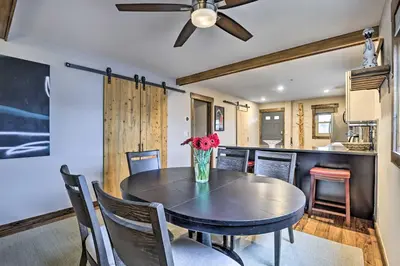 a dining room with a table with a vase of flowers at Main Street Frisco Condo with Private Patio! in Frisco