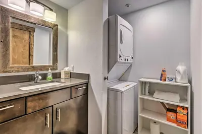 a bathroom with a sink and a washer and dryer at Main Street Frisco Condo with Private Patio! in Frisco