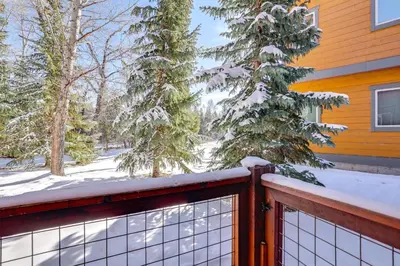 a snow covered fence in front of a house at Ski and Explore Silverthorne Gem with Hot Tub Access! in Silverthorne