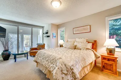 a bedroom with a bed and a chair and windows at Less Than 1 Mi to Dtwn Creekside Frisco Home with Fire Pit in Frisco