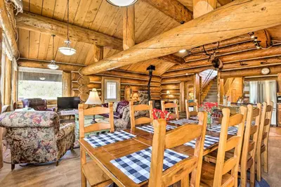 a dining room with a table and chairs in a log cabin at Less Than 1 Mi to Lake Granby Log Cabin with Fire Pit in Grand Lake