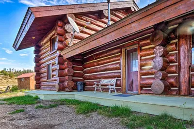 a wooden cabin with a bench on the porch at Less Than 1 Mi to Lake Granby Log Cabin with Fire Pit in Grand Lake