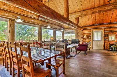a dining room with a table and chairs in a cabin at Less Than 1 Mi to Lake Granby Log Cabin with Fire Pit in Grand Lake