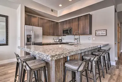 a kitchen with a large island with bar stools at 7 Mi to Keystone Waterfront Home with Scenic Views in Silverthorne