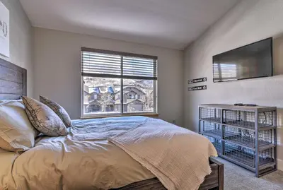 a bedroom with a bed and a tv and a window at 7 Mi to Keystone Waterfront Home with Scenic Views in Silverthorne