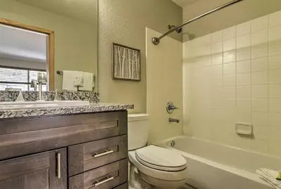 a bathroom with a toilet and a tub and a sink at 7 Mi to Keystone Waterfront Home with Scenic Views in Silverthorne