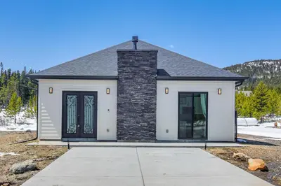 a small white house with a black roof and doors at Romantic Mountain Retreat with Scenic Views! in Idaho Springs