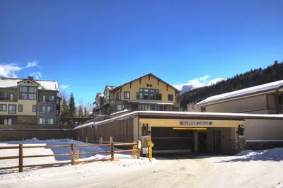 a building with a parking lot in the snow at Slopeside in Keystone