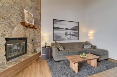 a living room with a couch and a fireplace at Balcony and Ski Slope Views Idyllic Granby Condo! in Granby