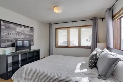 a bedroom with a bed and a window at Balcony and Ski Slope Views Idyllic Granby Condo! in Granby