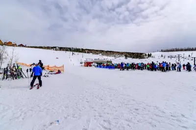 a group of people standing around in the snow at Balcony and Ski Slope Views Idyllic Granby Condo! in Granby