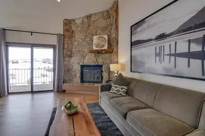 a living room with a couch and a fireplace at Balcony and Ski Slope Views Idyllic Granby Condo! in Granby