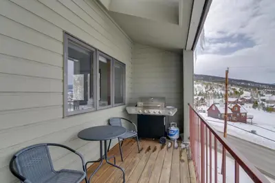 a balcony with two chairs and a table and a window at Balcony and Ski Slope Views Idyllic Granby Condo! in Granby