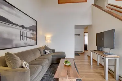 a living room with a couch and a tv at Balcony and Ski Slope Views Idyllic Granby Condo! in Granby