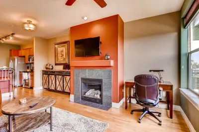 a living room with a fireplace and a tv at Mountain Views Luxury Condo in the DTC in Centennial