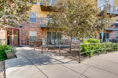 a sidewalk in front of a brick building with a tree at Mountain Views Luxury Condo in the DTC in Centennial