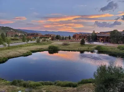a view of a pond at sunset in a resort at Relax, Adventure, Views, Amenities+Memories (Full) in Granby