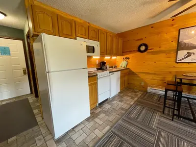 a kitchen with a white refrigerator and a table at Relax, Adventure, Views, Amenities+Memories (Full) in Granby
