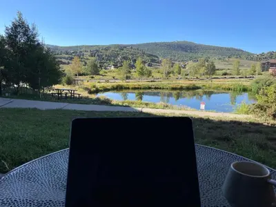 a laptop sitting on a table in front of a lake at Relax, Adventure, Views, Amenities+Memories (Full) in Granby
