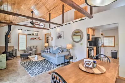 a living room with a table and a couch at 4 Mi to Grand Lake Mtn-View Cabin with Fire Pit! in Grand Lake