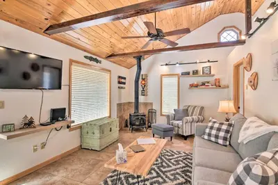 a living room with a couch and a table at 4 Mi to Grand Lake Mtn-View Cabin with Fire Pit! in Grand Lake