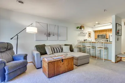 a living room with a couch and a table at Walkable Frisco Condo Mtn Views and Shared Hot Tub! in Frisco