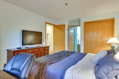 a bedroom with a bed and a television on a dresser at Walkable Frisco Condo Mtn Views and Shared Hot Tub! in Frisco