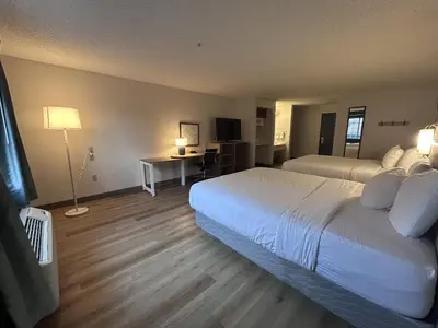 a bedroom with two beds and a desk and a television at Quality Inn Denver Tech Center in Englewood