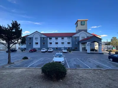 a large building with a car parked in a parking lot at Quality Inn Denver Tech Center in Englewood