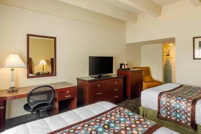 a hotel room with two beds and a desk and a television at Inn at the Highland Denver Downtown in Denver
